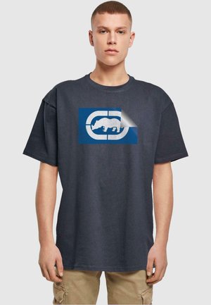 Mørkegrå bomulds t-shirt med et blåt rektangulært logo, der har en styliseret hvid bjørn, som ser ud til at skalle af i det ene hjørne.
