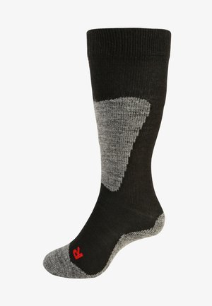 Zwarte en grijze kniekous met ribbelboord, versterkte hiel en teen, en logo in het rood bij de enkel. Gemaakt van een gestructureerde mix van materialen.