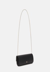 Black leather crossbody bag with a curved shape, featuring a silver chain strap and a small gold accent on the front. Smooth texture.