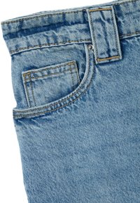 Jeans in denim azzurro chiaro con una leggera scoloritura. Caratteristiche includono una tasca frontale, dettagli cuciti e un bottone metallico in vita.