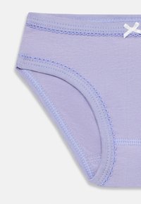 Mutande in cotone lilla con cuciture ondulate lungo la vita e le aperture delle gambe, con un piccolo fiocco bianco sul davanti.