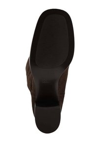 Brązowy zamszowy but na wysokim obcasie z gładką, czarną gumową podeszwą. Podeszwa zewnętrzna ma fakturowany wzór antypoślizgowy. Nazwa marki "MNG" widoczna na podeszwie.