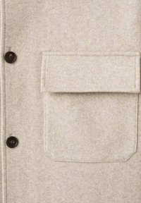 Beige wollen blend jas met een zachte textuur, voorzien van donkerbruine knopen, een borstzak en een gestructureerd ontwerp.