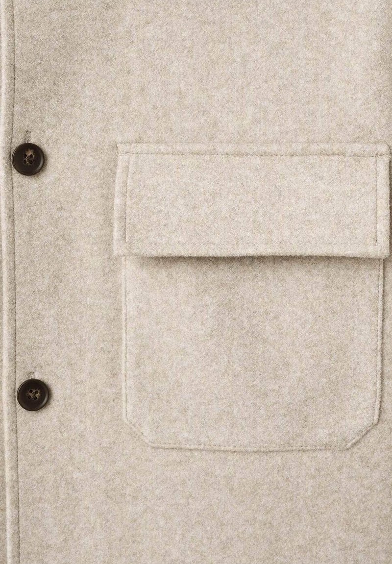 Cappotto in misto lana beige con una texture morbida, dotato di bottoni marroni scuri, una tasca sul petto e un design su misura.