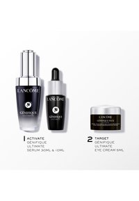 Bouteilles de sérum Lancôme Génifique Ultimate : une haute, dégradé du sombre au lumineux ; une courte, noire ; et un pot de crème pour les yeux noir avec un couvercle argenté.