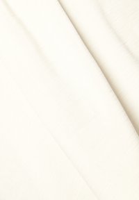 Teksturowana tkanina w jasnym kolorze kremowym, charakteryzująca się gładką powierzchnią z subtelnymi variantami splotu. Miękka i lekka w wyglądzie.