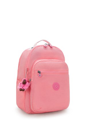Pink nylon backpack with rounded design, dual zippered compartments, front pocket, and a monkey keychain accent.