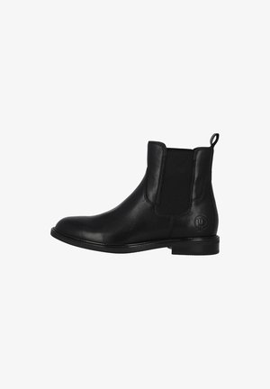 Bottine Chelsea en cuir noir avec panneaux élastiques latéraux, bout arrondi, languette de traction et semelle en caoutchouc plate avec un détail logo discret.