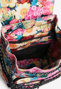 Zaino con motivo floreale caratterizzato da fiori vivaci su uno sfondo scuro, dotato di scomparti interni e tasche in rete per l'organizzazione.