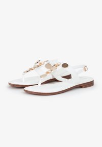 Witte sandalen met een tussenruimte ontwerp, voorzien van gouden ronde accenten op de bovenste band en een vlakke houten zool.