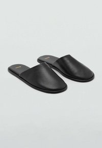 Infradito in pelle nera con design a punta, suola piatta e texture liscia. Logo sottile impresso sulla soletta.