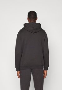 Dunkelgrauer Hoodie mit Kapuze und Kordelzug, gerippten Bündchen und Saum. Einfaches Design und Textur. Die Ansicht zeigt die Rückseite ohne weitere Details.
