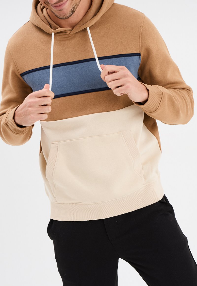 Felpa con cappuccio in tonalità beige, sabbia e blu. Presenta una tasca frontale, lacci regolabili e polsini e orlo a costine.