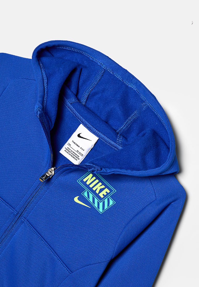 Felpa blu con zip realizzata in tessuto morbido, caratterizzata da un grande logo Nike giallo e blu sul petto, con cappuccio foderato e zip robusta.