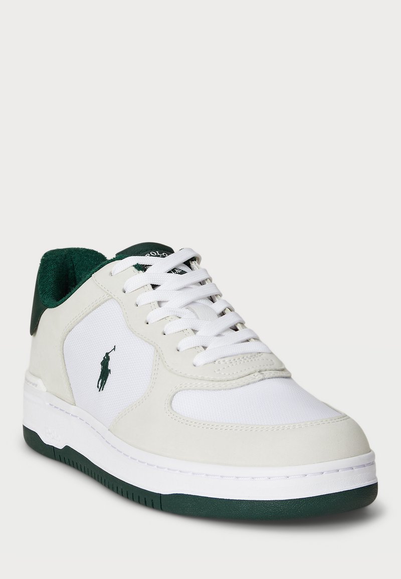 Sneaker bianca con accenti verdi, caratterizzata da un mix di materiali lisci e texturizzati, dettagli perforati e un logo visibile sul lato.