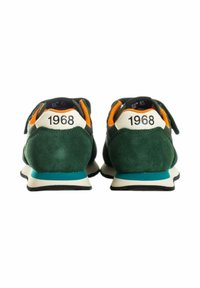 Sneakers in suede verde con accenti bianchi e teal, dotati di una suola imbottita e dettaglio sul tallone che mostra l'anno "1968".