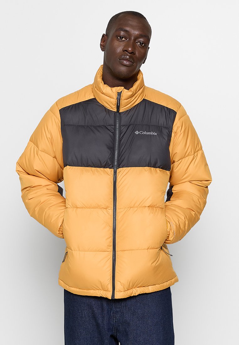 Chaqueta tipo plumas con cuerpo amarillo y yugo negro, que presenta un collar alto, cremallera frontal y dos bolsillos laterales. Diseño ligero y con aislamiento.