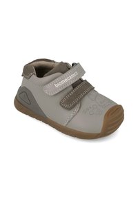 Zapato infantil gris con parte superior de sintético suave, correa de velcro, suela de goma marrón y gráficos de animales juguetones en el frente.