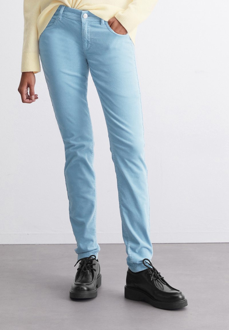 Ljusblå slim-fit jeans i bomullsblandning med en slät textur. Bärs med svarta snörskor med tjock sula.