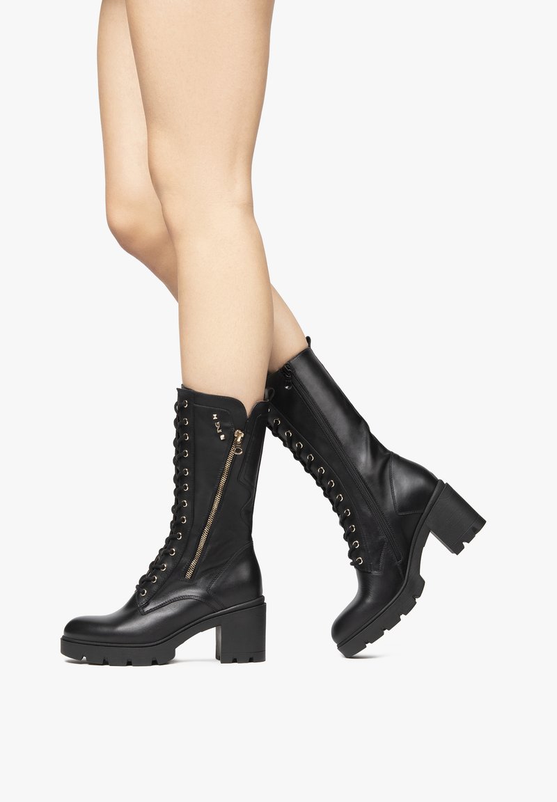Black leather knee-high boots with a chunky heel, featuring a side zipper and decorative eyelet lacing along the front.