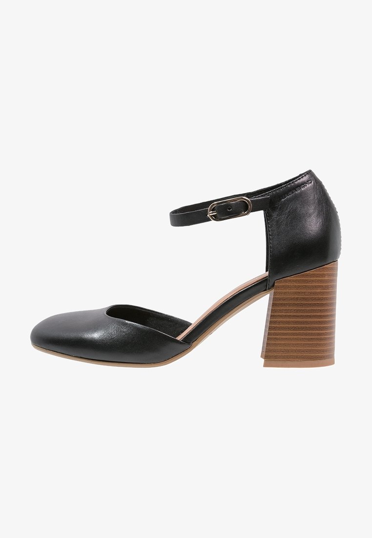 Chaussure femme en cuir noir avec bout arrondi, bride à la cheville avec boucle dorée et talon bloc empilé en bois.