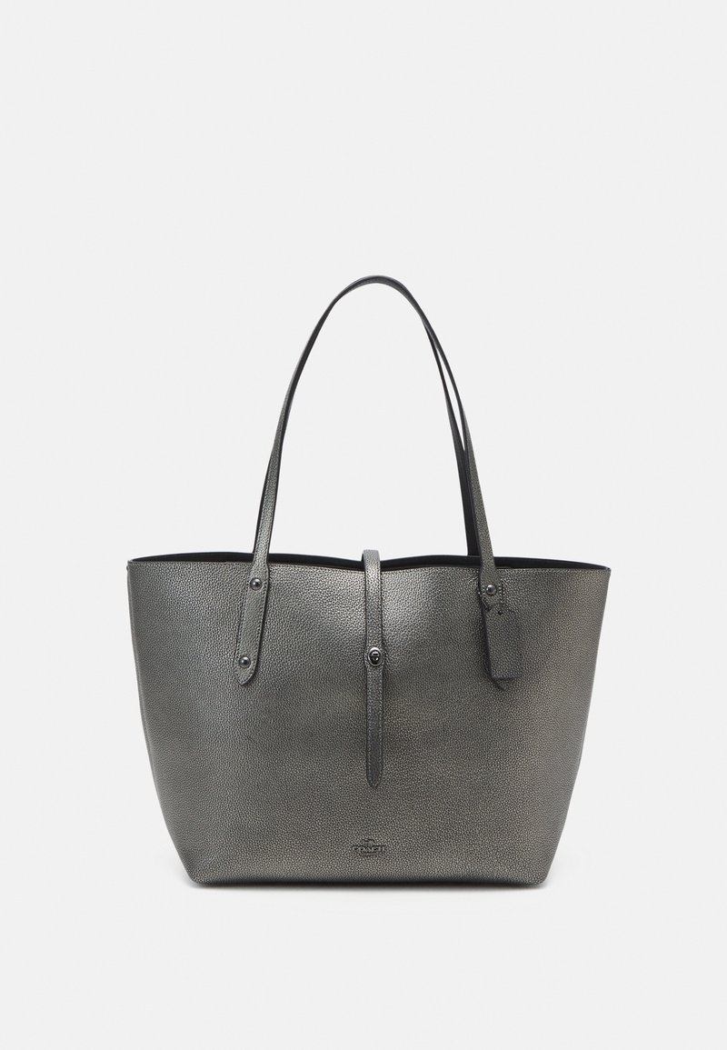 Sac cabas en cuir texturé gris avec deux longues poignées, une petite lanière avec fermeture pression et une étiquette suspendue à une poignée.
