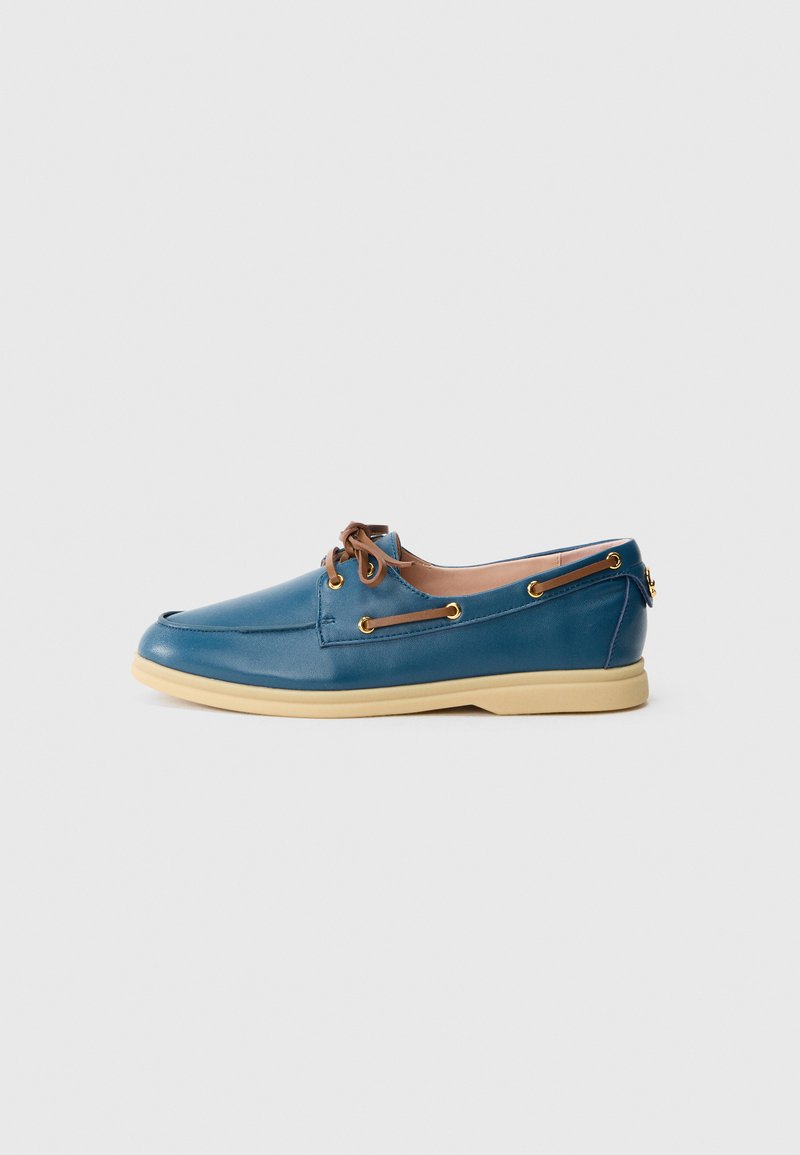 Blue leather boat shoe with beige sole, brown laces threaded through gold eyelets, shown in side profile on a white background.