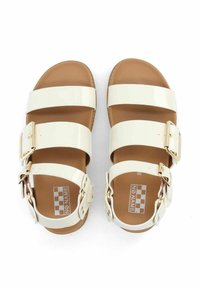 Witte gepatineerde leren sandalen met drie brede banden en metalen gespen, bruine binnenzolen, platte zolen en een eenvoudig, open teenontwerp.