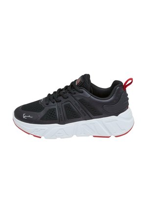 Black athletic shoe with mesh upper, white sole featuring "KANI" embossed, red accents, and black laces. Lightweight with cushioned heel.