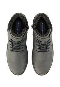 Botas de tobillo de cuero gris con un forro de piel sintética negra texturizada, que cuentan con cordones planos, ojales de metal y una etiqueta con el logo en la lengüeta.