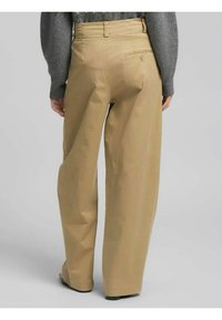 Pantaloni beige a gamba larga con vita alta, dotati di tasca posteriore, tessuto di cotone liscio e leggere trame di pieghe.