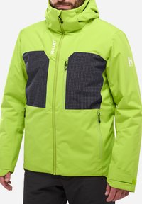 Veste isolée verte lime avec des panneaux à carreaux noirs. Présente un col haut, des poches zippées et des poignets ajustables.
