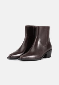 Stivali ankle in pelle marrone con punta affusolata, cerniere laterali e tacco basso a blocco; superficie liscia con una leggera lucentezza.