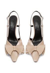 Décolleté in vernice beige con un grande fiocco sulla punta, design a punta e una sottile cinghia alla caviglia. Interno nero.