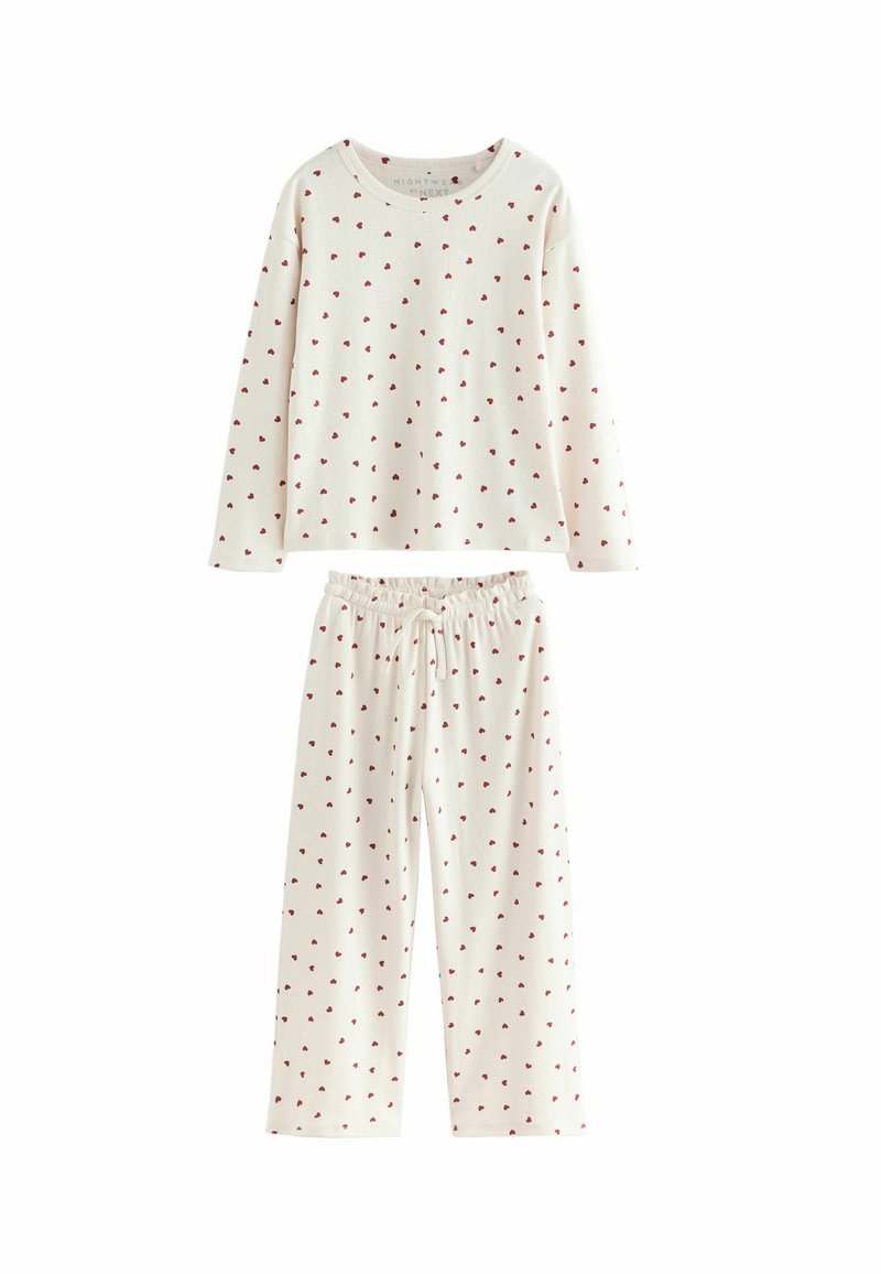 Valge puuvillane pidžaamakomplekt, mis koosneb pikast varrukast topist ja elastse vöökohtaga pükstest, mõlemas mõlemal on üle kogu pinna väikesed punased südamekirjad.