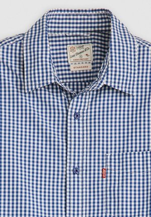 Blue and white gingham check shirt with a standard collar, one chest pocket, and a Levi’s tag. Features blue buttons and contrast stitching.