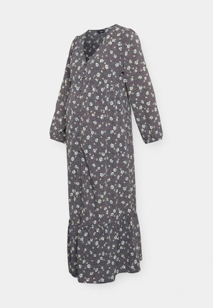 Vestido de maternidade longo e escuro com padrões florais, mangas longas, decote em V e bainha com volantes em camadas. Apresenta pequenos padrões de flores azuis e brancas sobre um fundo escuro.