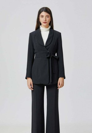 NOUÉ À LA TAILLE - Manteau court - noir