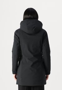 Zwarte geïsoleerde jas met een capuchon, langere silhouet, gladde stof en een naaddetail bij de taille. Minimalistisch ontwerp, geen zichtbare logo's.