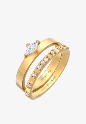 L'ensemble de bagues en argent plaqué or se compose d'une bague centrale ornée d'un diamant marquise et d'un anneau serti de petites pierres claires le long de son bord.