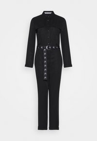 Salopette noire à manches longues, devant à boutons, deux poches poitrine et une ceinture à motifs. Le tissu semble lisse avec une coupe ajustée.