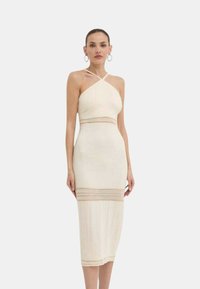 Abito crema al ginocchio con design a collo all'americana, caratterizzato da dettagli in pizzo orizzontali di colore contrastante in vita e all'orlo.