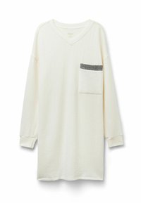 Camisa de manga larga color crema con escote en V, textura acanalada vertical y un bolsillo en el pecho con diseño de cuadros en blanco y negro.