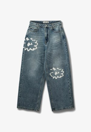 Vaqueros azules de pierna ancha con cintura alta y detalles abstractos en pintura blanca en el muslo izquierdo y la zona de la rodilla derecha.