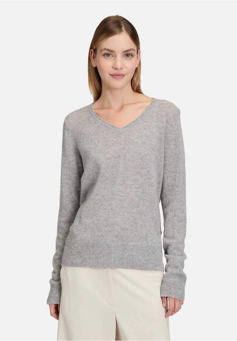 Šedý svetr s výstřihem do V vyrobený z měkké pleteniny, s žebrovanými manžetami a lemem, s uvolněným střihem a jemnou texturou.
