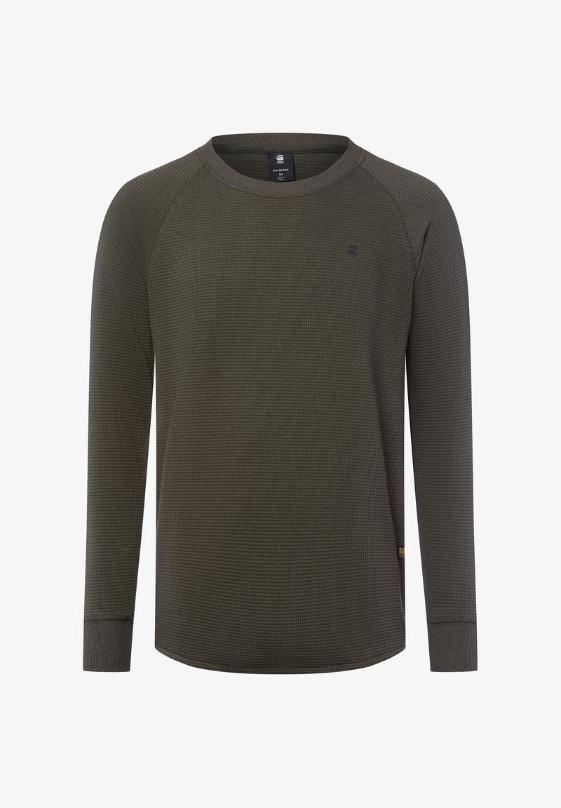 T-shirt à manches longues, vert olive foncé en maille gaufrée, avec un petit logo sur la poitrine et des poignets côtelés, présenté sur fond blanc.