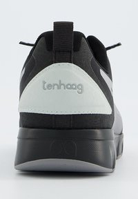 Schwarzer Sneaker mit einem strukturierten Obermaterial, weißen Akzenten und einem geschwungenen Fersendesign. Mit einem Logo auf der Rückseite und einer robusten Gummisohle ausgestattet.