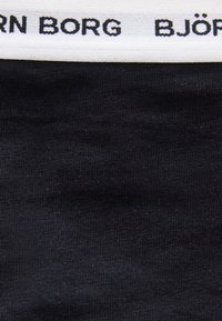 Μαύρο ύφασμα με λευκή ελαστική μέση που διαθέτει μαύρο λογότυπο κειμένου "BJÖRN BORG".