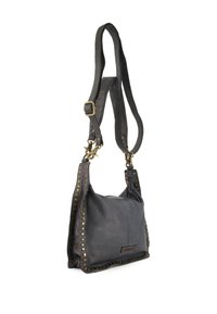 Černá kožená crossbody taška ve volném tvaru, zdobená zlatými hroty podél okrajů a s nastavitelním popruhem. Texturovaný povrch.