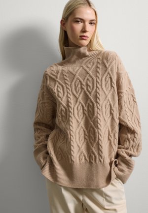 Suéter de punto de cable beige con cuello alto que presenta un patrón texturizado con diseños de diamantes y trenzas, puños acanalados y un corte relajado.